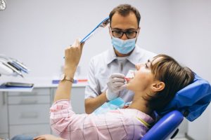 a woman is checking her teeth afer getting general dentistry treatment