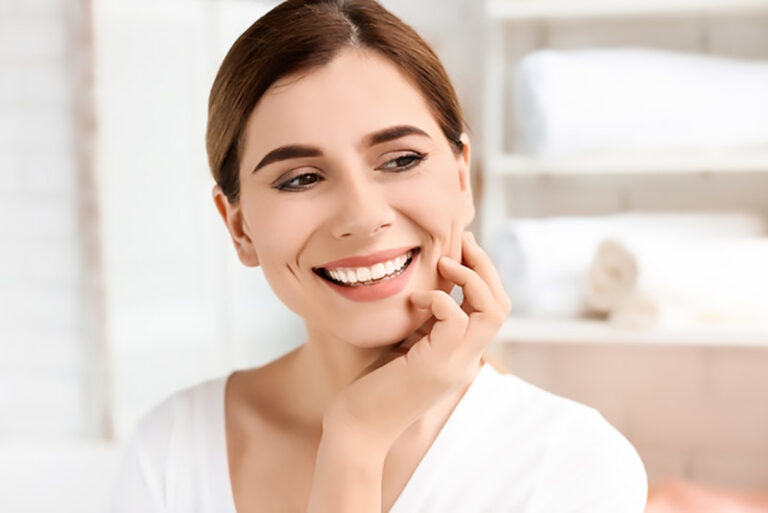 a lady is smiling after getting cosmetic dentistry treatment