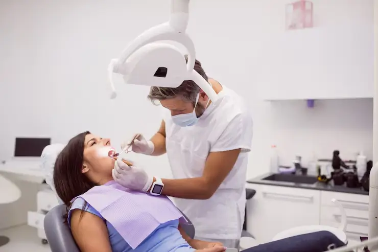 a lady is getting dental treatment from a dentist