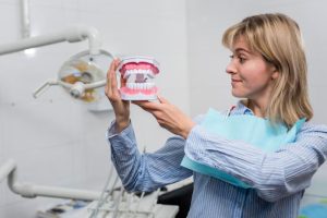 a dentist is showing the demo of dentures