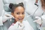 a kid is smiling while getting the dental treatment