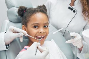 a kid is smiling while getting the dental treatment