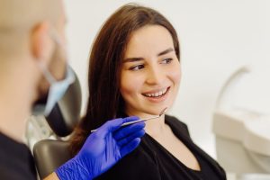 a lady is tallking to the dentist before getting dental crown treatment