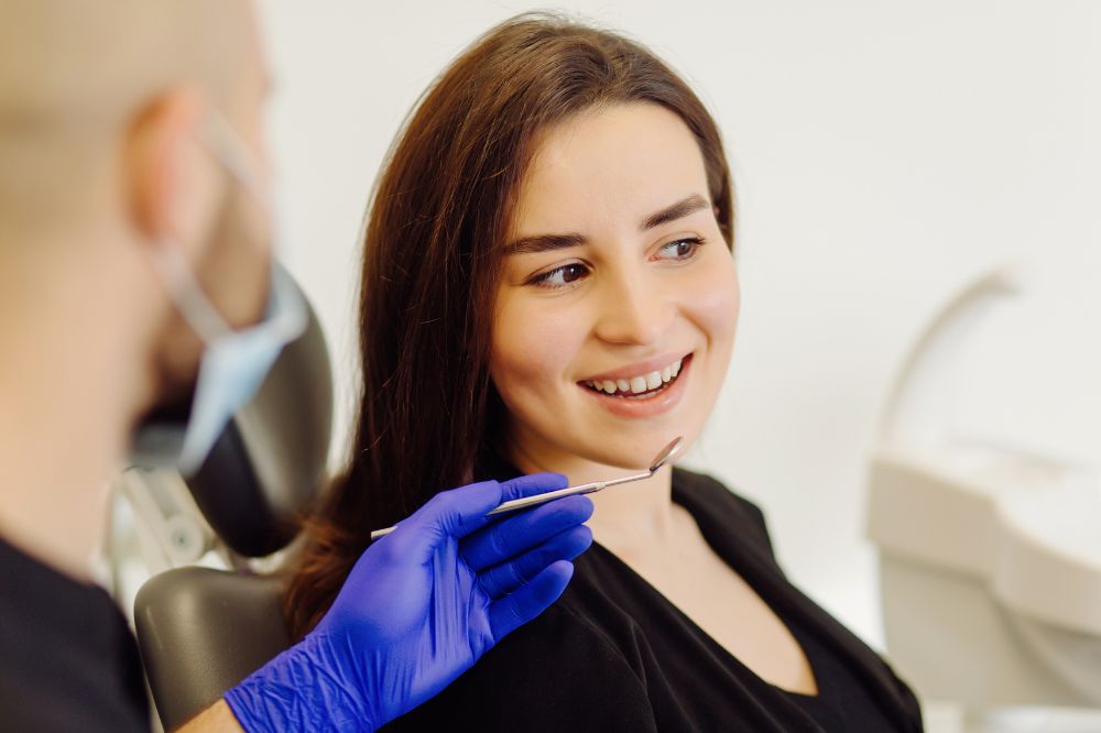 a lady is tallking to the dentist before getting dental crown treatment